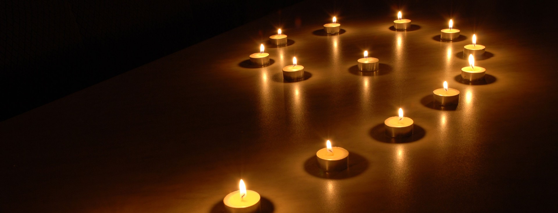 Warm tea lights in soft darkness