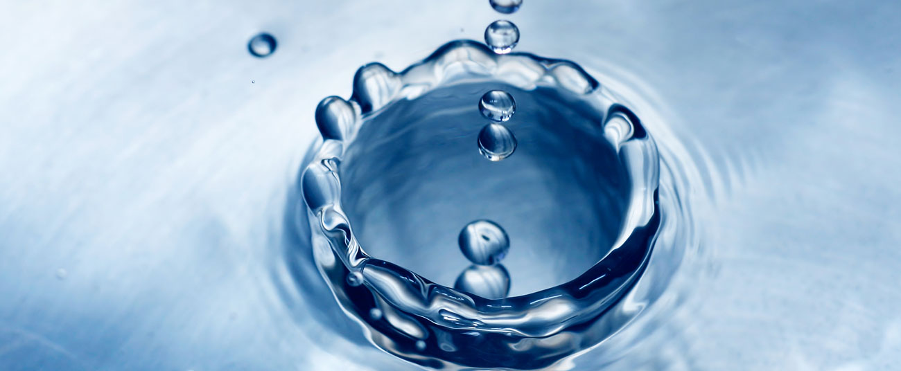 Crown of blue water droplets splashing — the still surface of attention that hypnosis cultivates